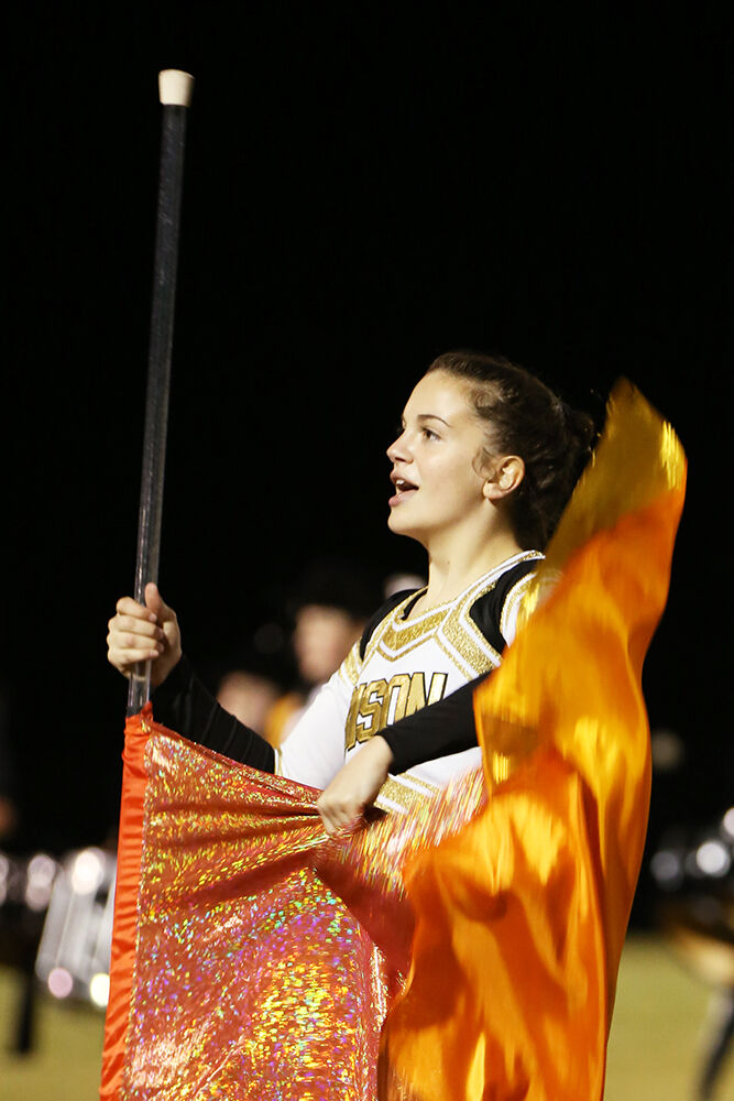 Madison Bartlett grabs her flag during the marching band performance